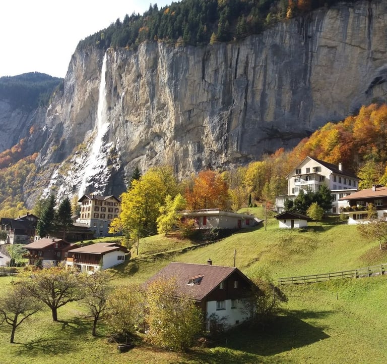 a mountain side view of a mountain with a waterfall in the background
