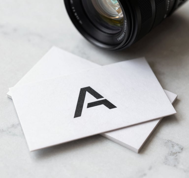 A high-contrast photo of a professional business card with a sleek, minimalist logo on a white marble surface, bright North American corporate lighting.