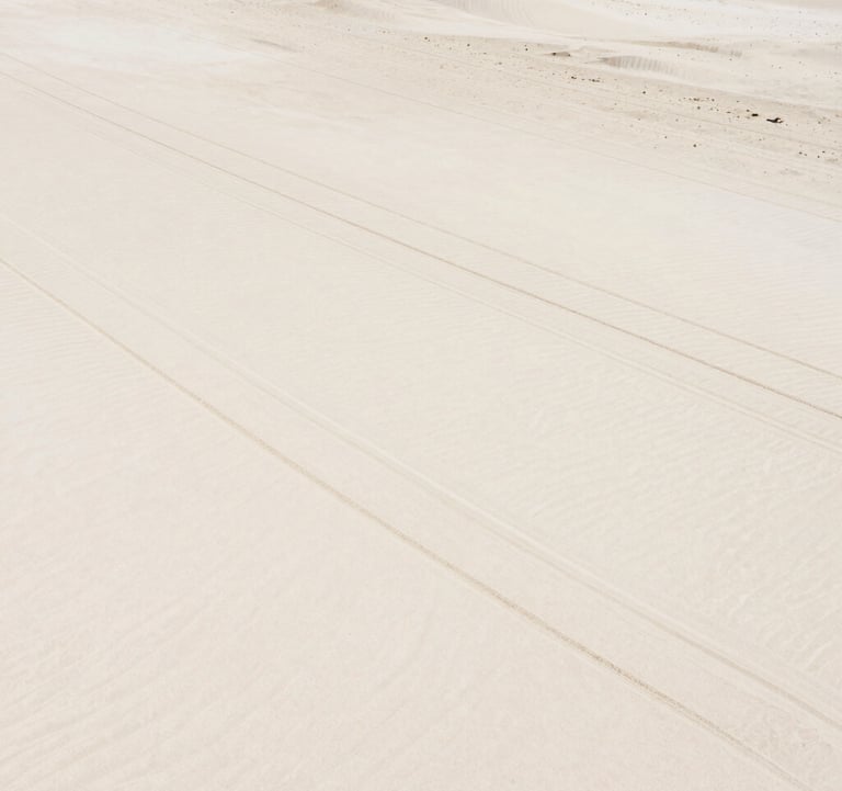 An aesthetic shot of a kite surf bar and lines laid out on white sand, minimalist and clean, capturing the preparation before the movement. Warm sunlit sand tones #DDCAB8 and #FAF8F5.