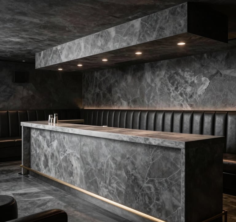 Interior of an exclusive members club, featuring dark leather upholstery, low slate charcoal lighting, and a pristine cool grey bar counter.