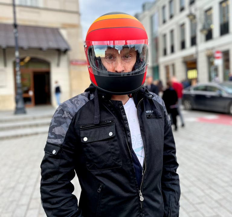 Motocyklista prezentujący kask retro DMD Rocket Fuoco na rynku starego miasta w Warszawie