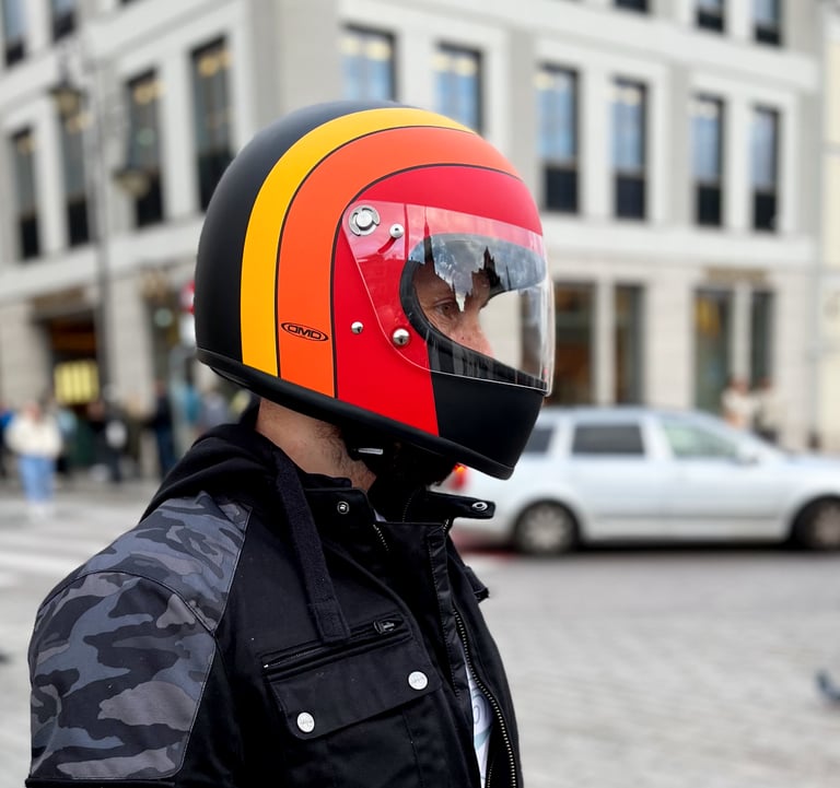 Motocyklista prezentujący kask retro DMD Rocket Fuoco na rynku starego miasta w Warszawie