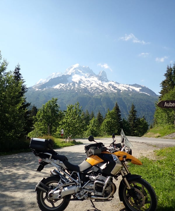 a motorcycle parked on a dirt road near a mountain