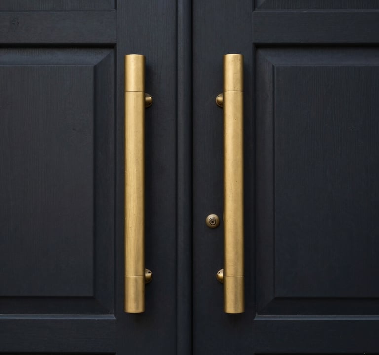 Close-up of a luxury property entrance in South America / Ecuador with metallic gold accents and a deep charcoal black door. Minimalist and corporate style.