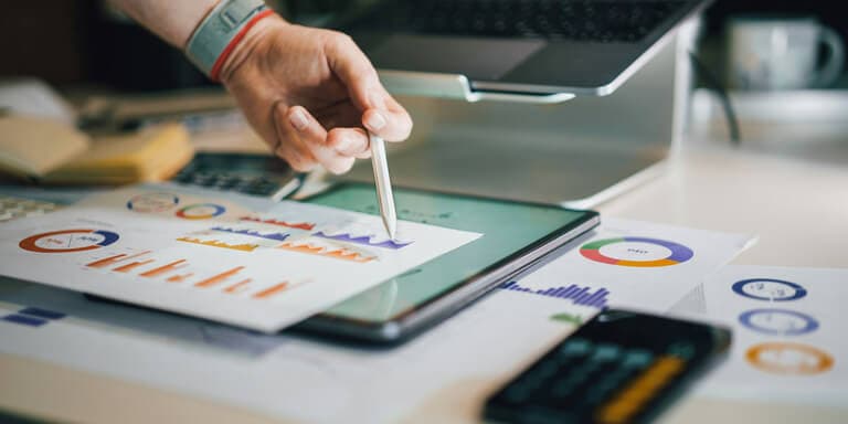 Tablet showing graph with person pointing, illustrating measurable business results.