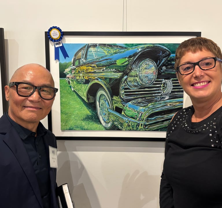 Photo of Sue and Peter Cheung (Judge) displaying 2nd place win painting