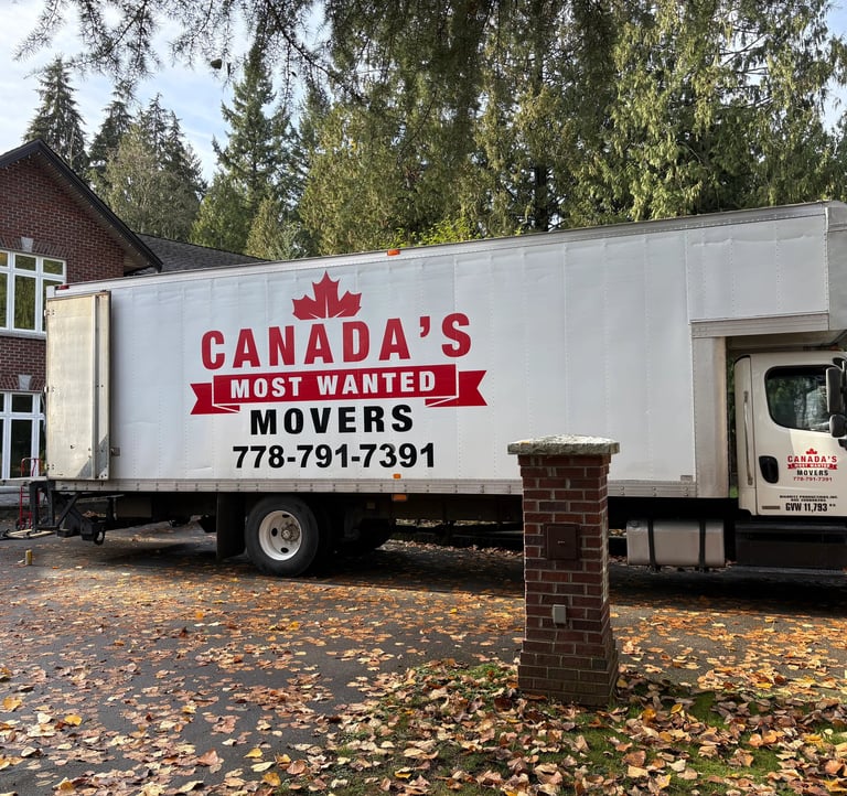 Canada’s Most Wanted Movers truck positioned outside a large brick home for a residential move in Langley..