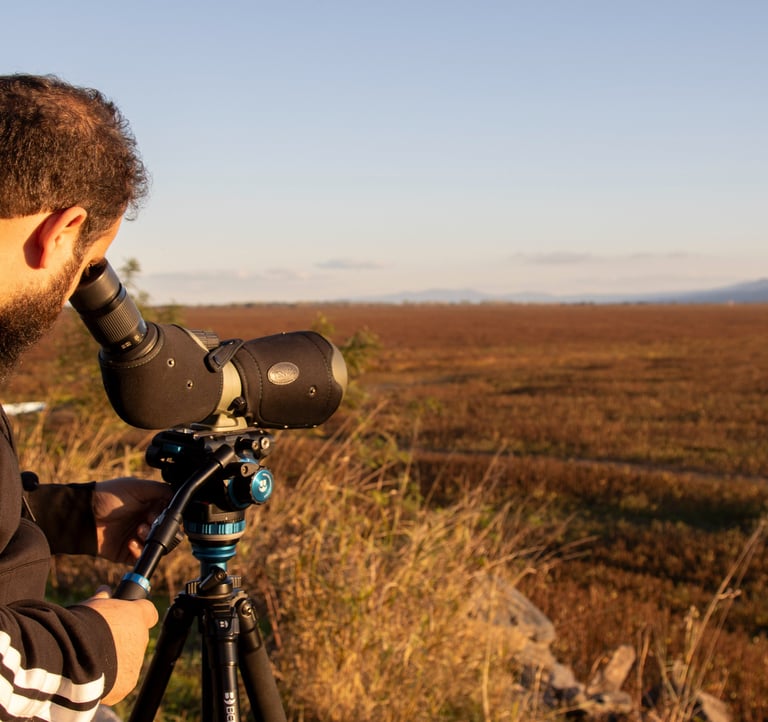 a man in a black jacket and a camera on a tripod