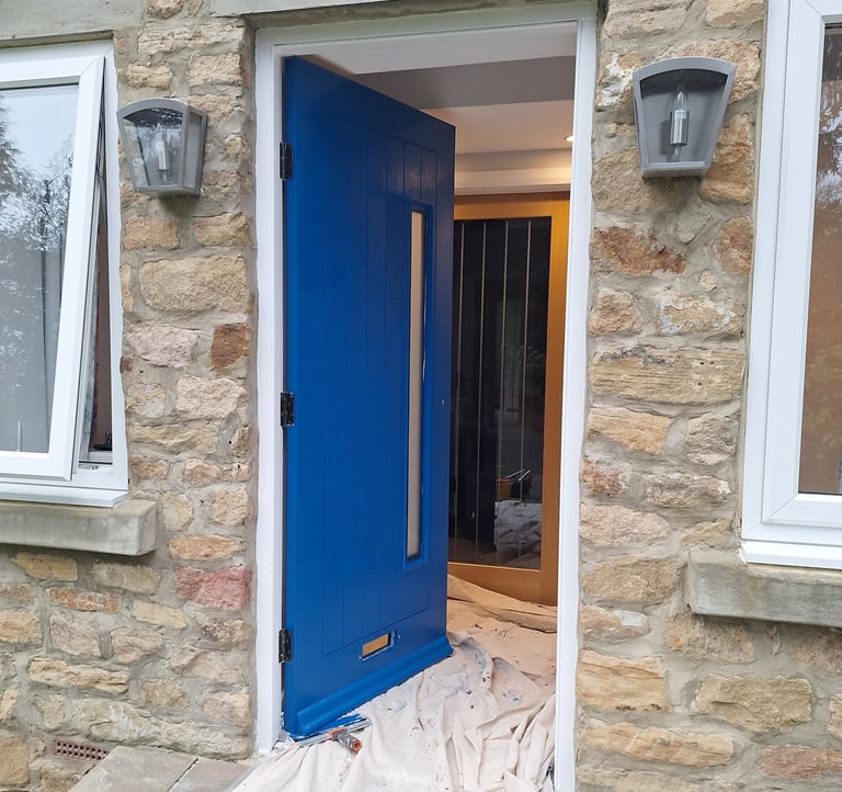 an open blue door with a dust sheet on the ground