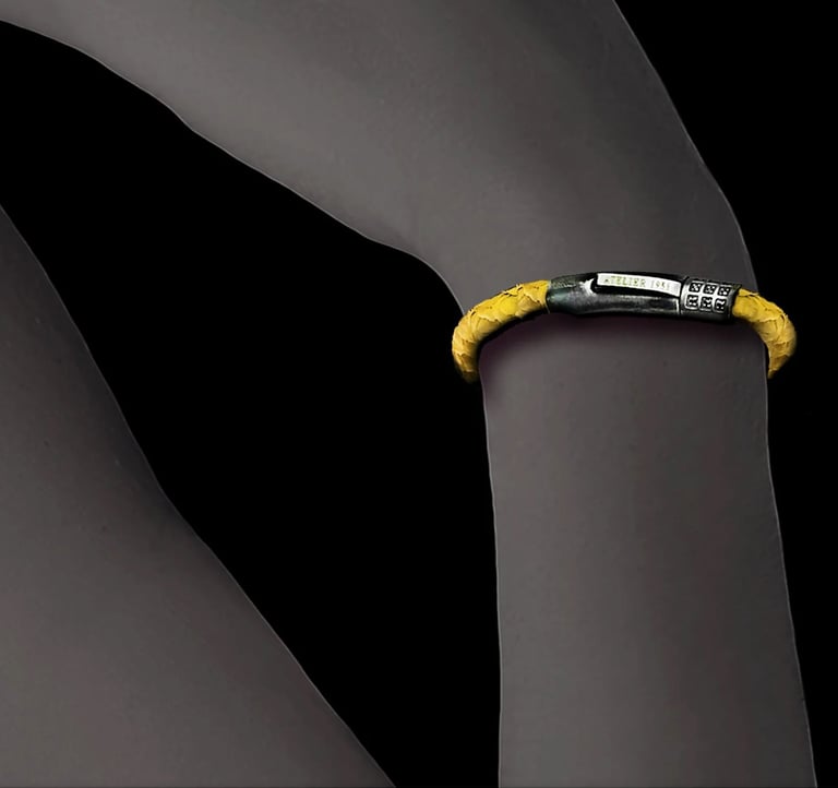 A luxury yellow braided fish leather bracelet with a silver clasp worn on a wrist.