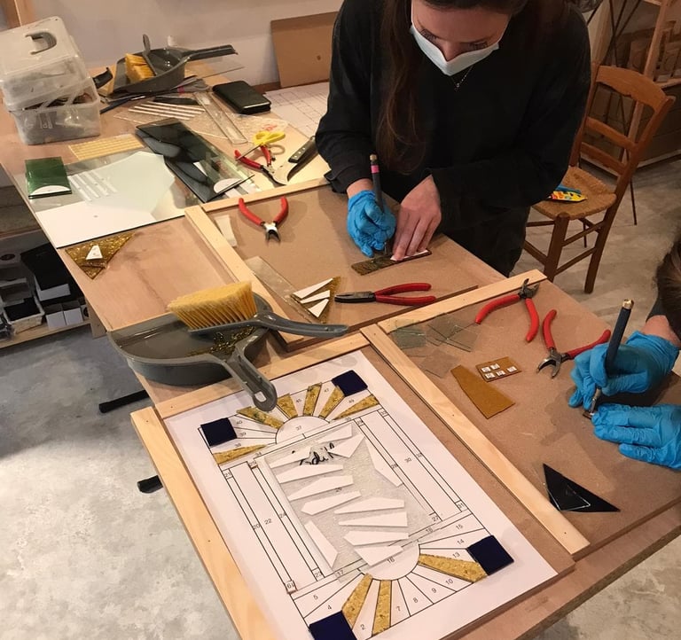 Découpe du verre lors d'un stage d'initiation au vitrail au plomb, atelier Paris 17e