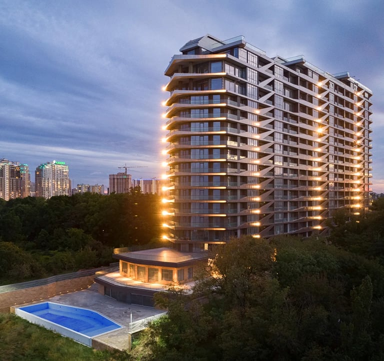 fotografia architektoniczna wielemieszzkzniowego gmachu po zachodzie słońca 