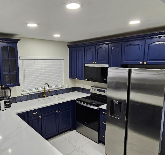 a kitchen with a refrigerator, microwave, and oven