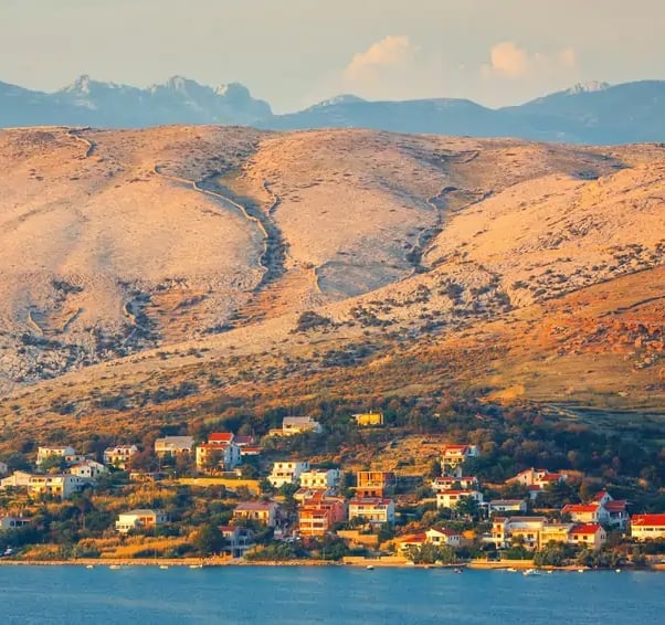 Pogled na selo na otoku Pagu okruženo brdima.