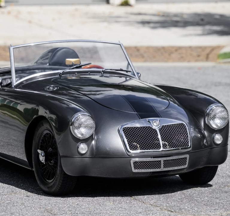 3/4 profile view of a silver 1958 MG MGA Roadster.