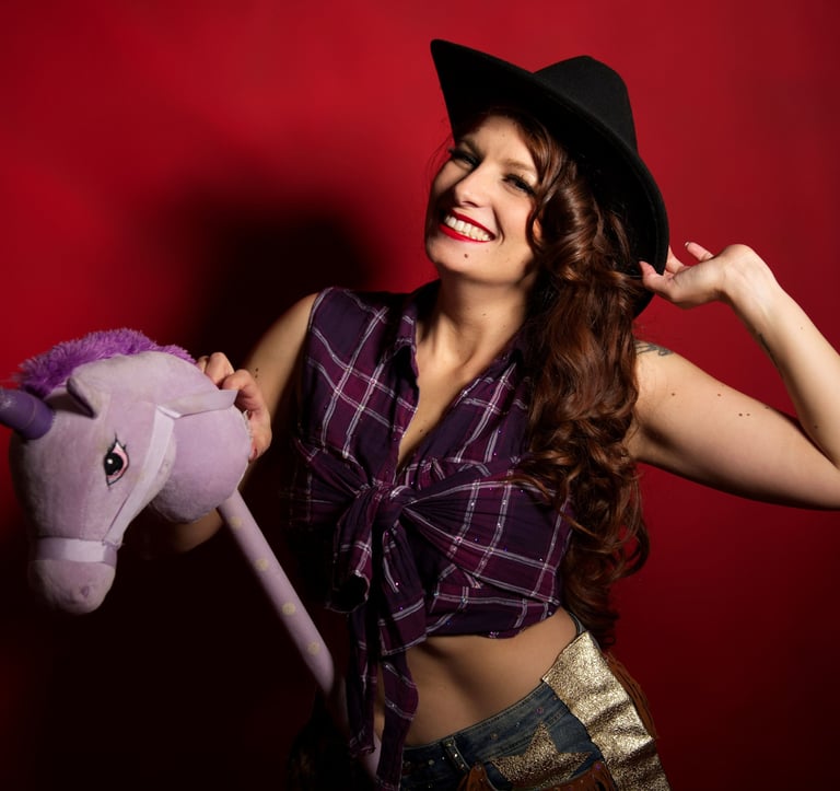 Pin up cowgirl avec chapeau et chemise à carreaux, sur un cheval en peluche
