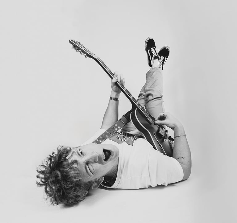 portrait of a man lying with a guitar and a guitar