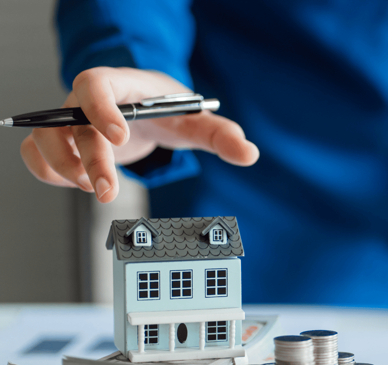 Estimation immobilière d'une maison. Le conseiller immobilier porte une chemise bleue et a un stylo.