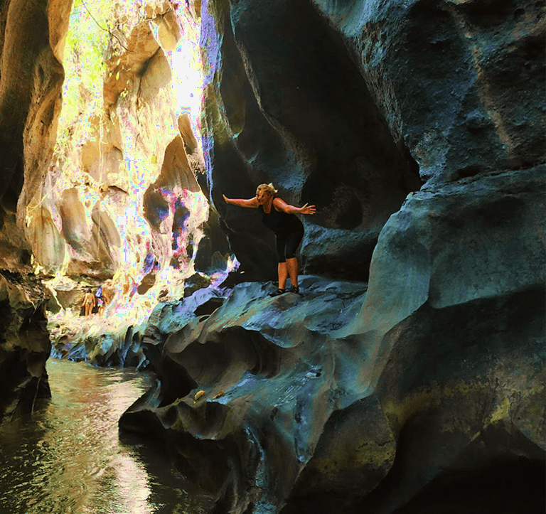 a person standing in a cave in a canyon