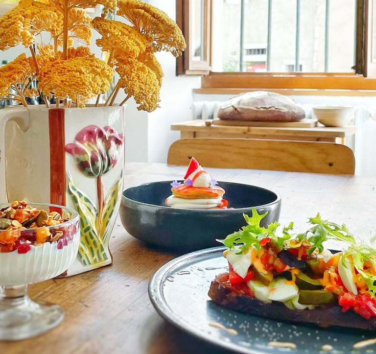a table with a vase of flowers and brunch with plates