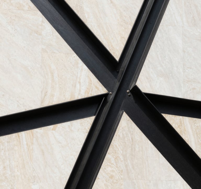 A sharp, editorial photograph of a modern Middle Eastern architectural detail. Sleek black steel intersecting with warm bone white limestone. The composition is clean, abstract, and exudes a sense of structured power and luxury.