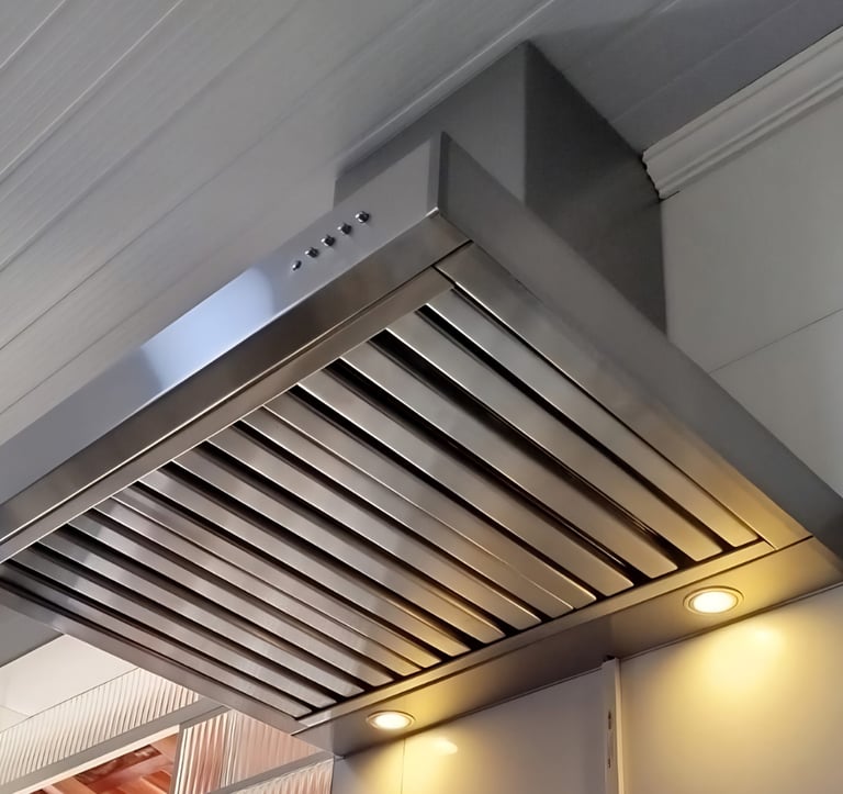 SIlha de cozinha moderna com coifa preta instalada acima de um cooktop a gás embutido