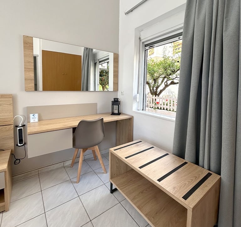 a bedroom with a desk and a bed in the background