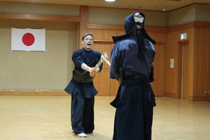 a man in a black suit and a woman in a black Kendo outfit