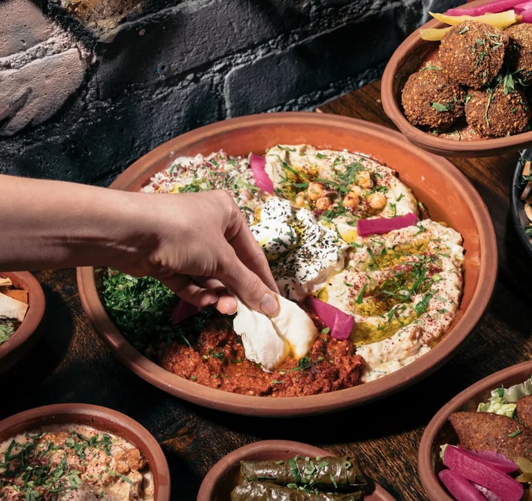 al badawi labneh and hummus dips being served