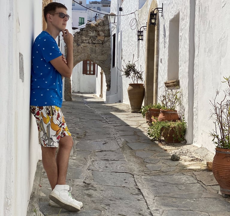 a man standing on a stone path in a narrow alley in Lindos village Rhodes Greece