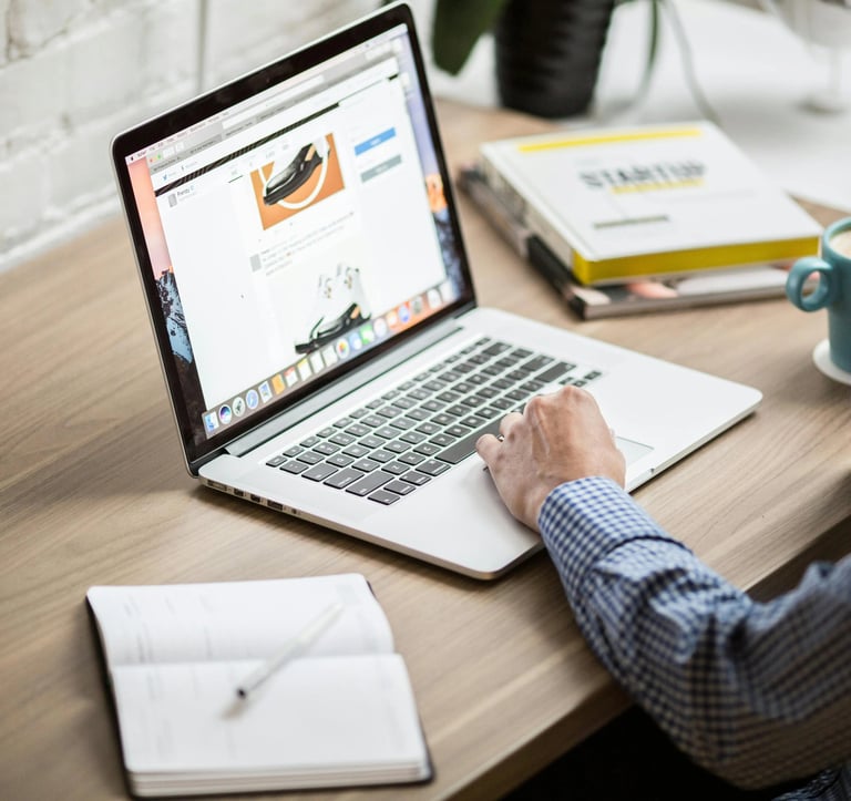 Un homme assis sur un bureau avec un ordinateur portable