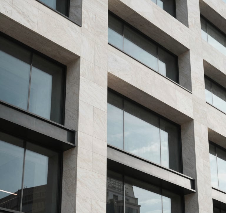 Close-up architectural detail of a premium modern building facade in Israel, showcasing high-quality stone and glass. Sharp lines and minimalist aesthetic, captured in soft daylight with a focus on luxury textures in white and grey materials.