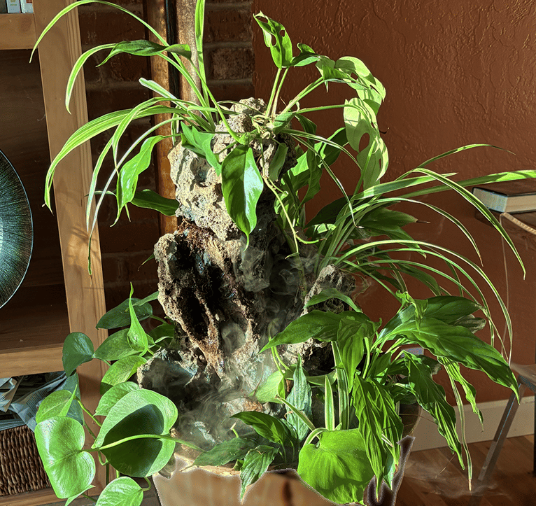 Large indoor waterfall sculpture by Phil Mikkelson with sculpted stone, mist, and a lush arrangement
