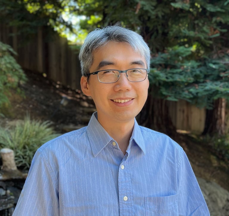 a physician in glasses and a blue shirt