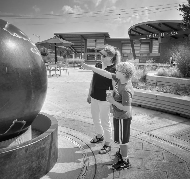 Photo of young boy and his mother looking at a Kugel Ball