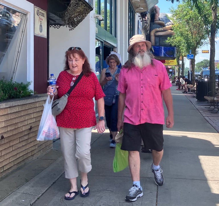 Man with white beard walking down Broadway Street