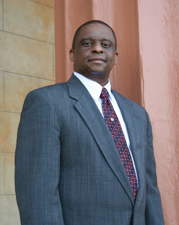Mark T. Stewart in a suit and tie standing in front of the Old Courthouse