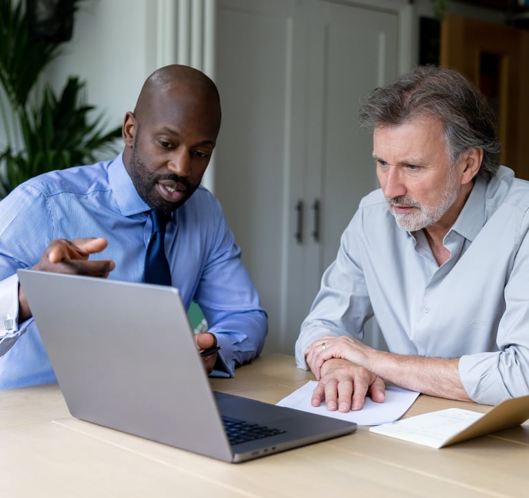two men sitting at a table with papers and papers