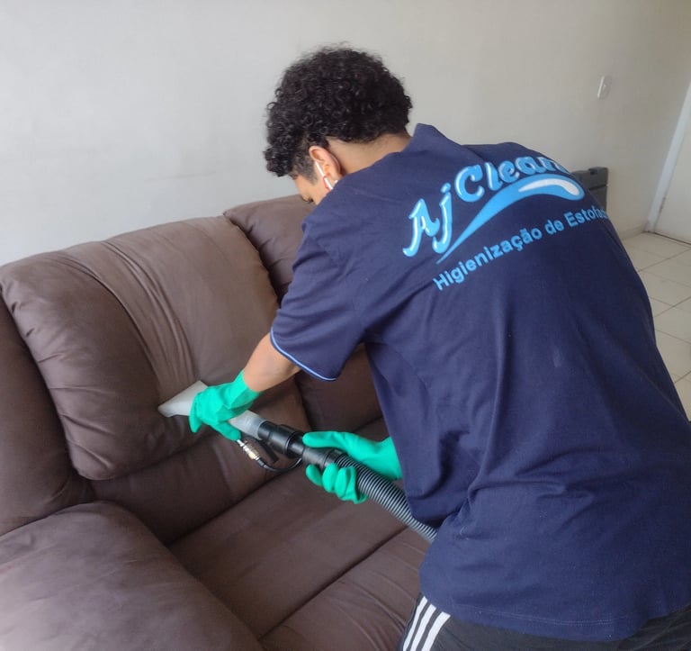 Equipe AJ Clean usando extratora para remover manchas e odores do estofado marrom.