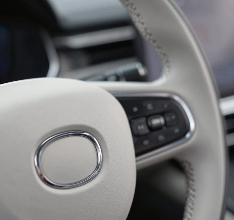 Macro shot of a high-end luxury car steering wheel, focusing on the fine leather stitching and the metallic logo. Minimalist composition with #CECECE and #272635 colors.
