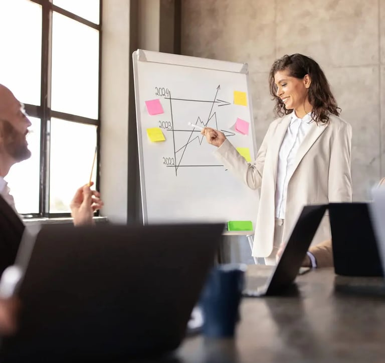 A happy business woman in a meeting room showing business growth on a small whiteboard