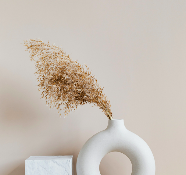 Un elegante vaso bianco con grano, evocando la tranquillità e il design minimalista di Borganthia 
