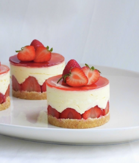three desserts on a plate with strawberries