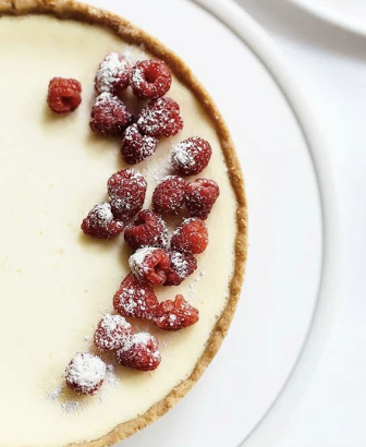 a dessert with raspberries and sugared cream