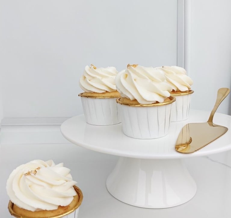 a cake with white frosting and cupcakes