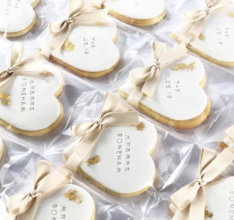 a bunch of cookies that are decorated with gold and white
