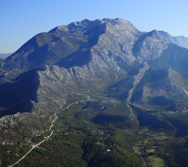 Aerial view of Biokovo mountain with rocky peaks and Adriatic Sea coastline.