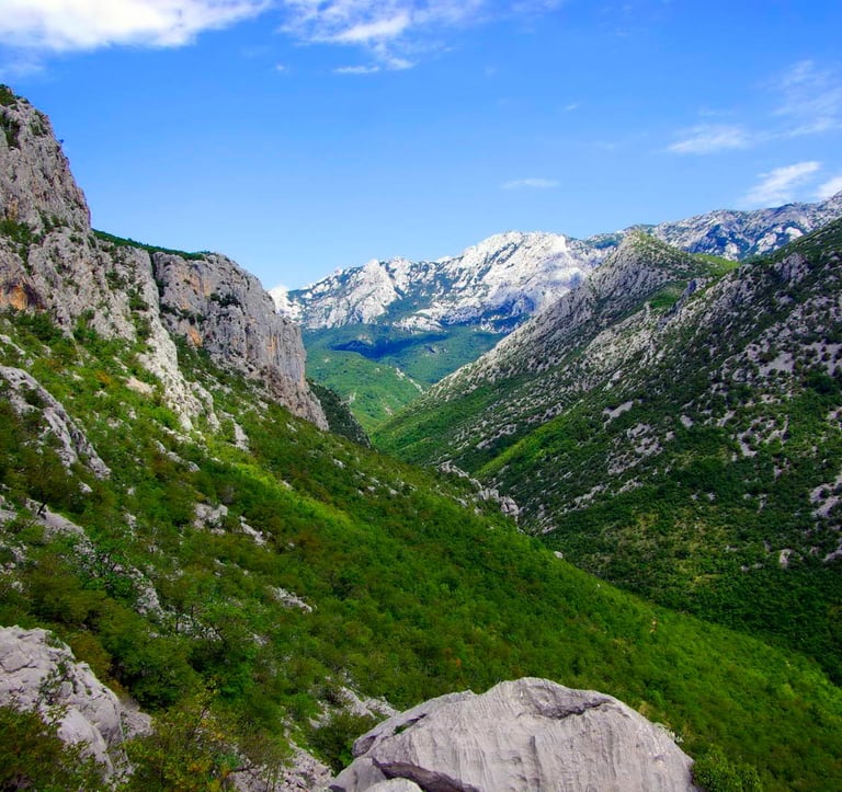 Rocky cliffs and canyons of Paklenica National Park against a backdrop of blue sky.