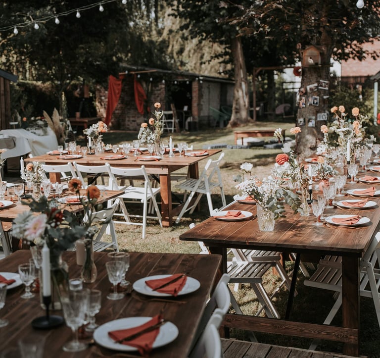 Un jardin avec plusieurs tables de mariage
