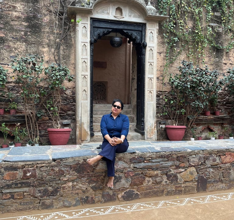a woman sitting on a stone wall with a door open